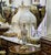Elegant vintage French-style beige table lamp featuring a beautifully cut crystal body accented with ornate gold leaf...