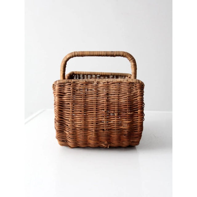 This vintage wicker basket offers a warm, organic accent with its rounded silhouette and naturally aged woven texture. The...