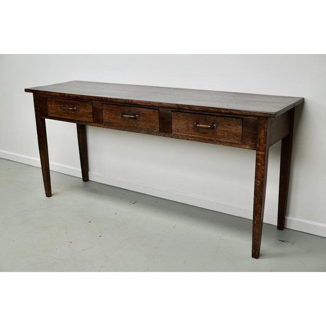 This elegant table was made in England. The table was made in solid oak with a beautiful grain pattern. It has a warm...