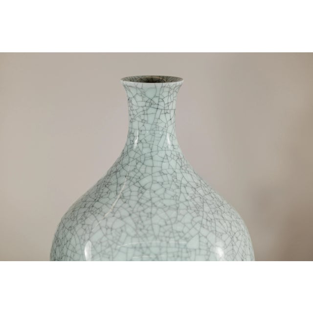 This elegant pair of porcelain vases features a light celadon grey glaze enriched by a dense and intricate crackle pattern...