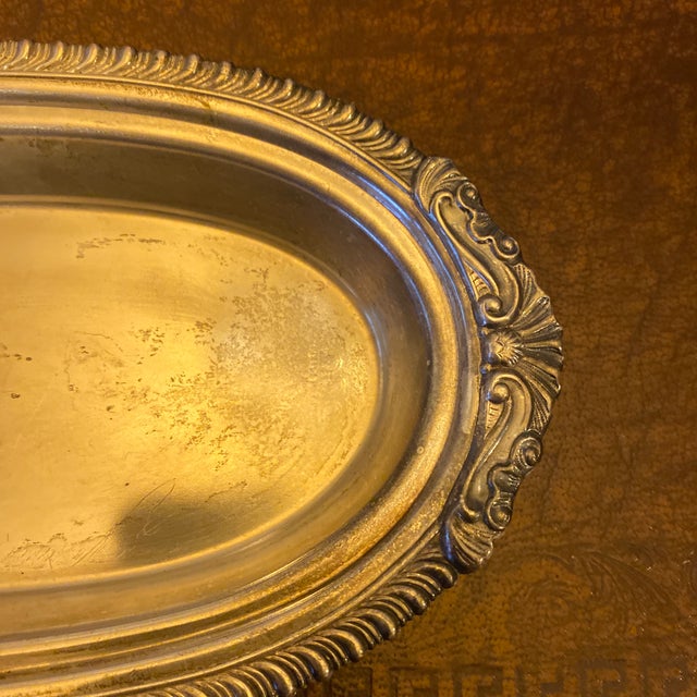 This elegant silver-plated oval serving tray features an intricate decorative edge and classic design, making it a...