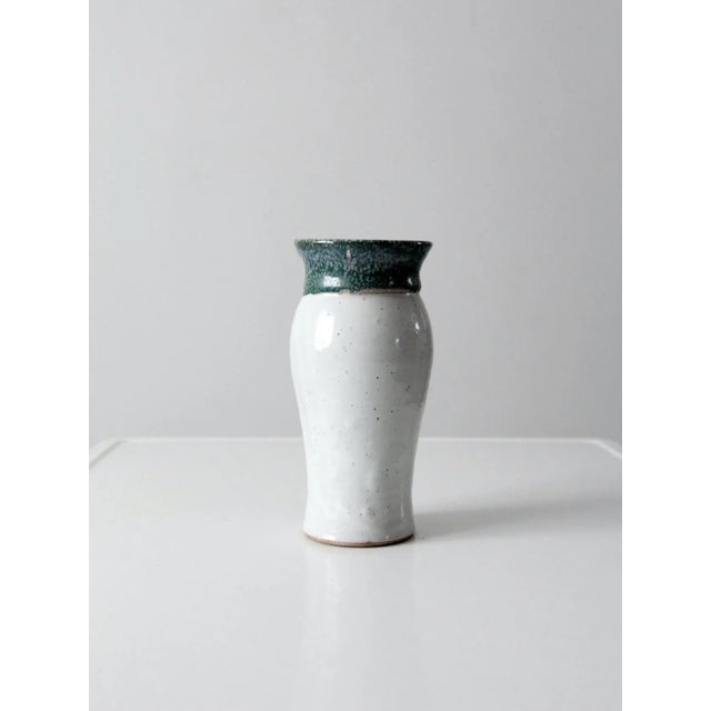 A vintage studio pottery vase, hand-crafted with a graceful form and artisanal presence. The surface is finished with a...