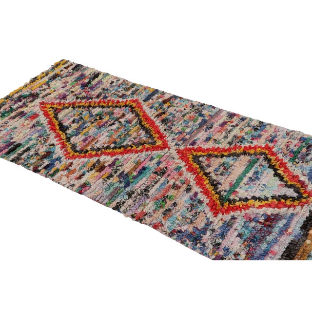 Hand-knotted in wool circa 1950-1960, this vintage 3x6 Moroccan runner rug is believed to hail from the Azilal tribe. On...