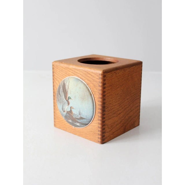 This vintage wooden tissue box cover features a decorative medallion depicting a pair of mallard ducks in a serene...
