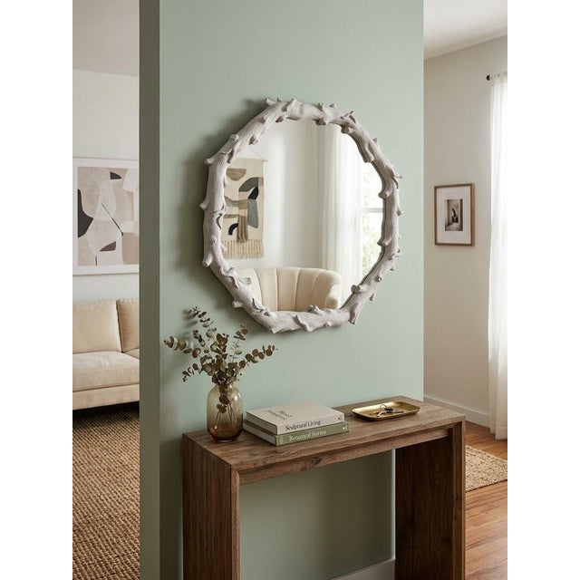 Sculptural round wall mirror featuring a dimensional faux-bois frame modeled as an overlapping arrangement of naturalistic...