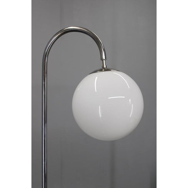 Elegant 1930s art deco floor lamp produced in czechoslovakia, constructed with a chrome-plated arched metal frame and a...