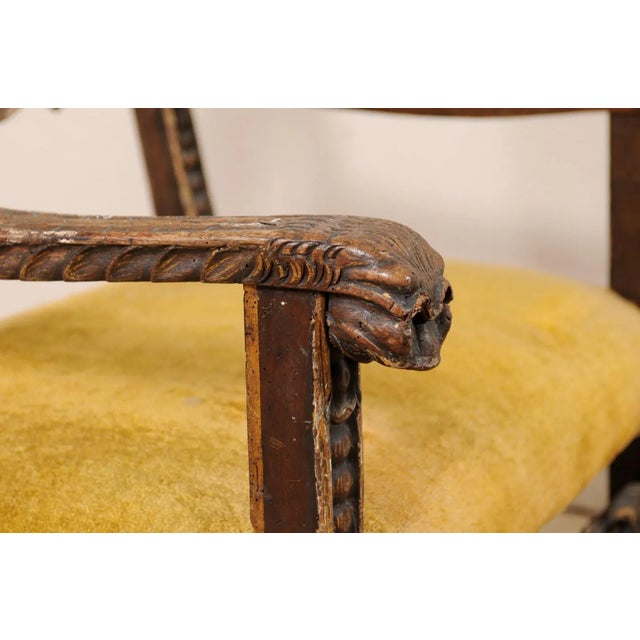 An Italian carved-wood Baroque armchair from the 18th century, possibly older. This antique chair from Italy has...