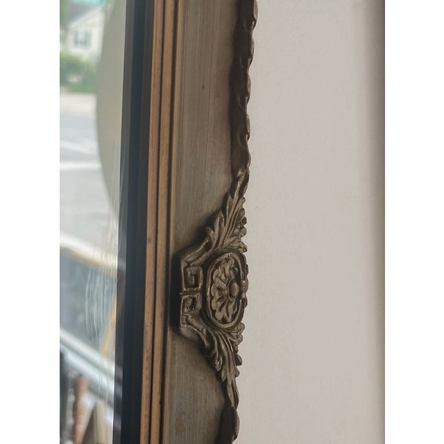 Vintage circa mid century 1970s art deco style wall accent mirror. Features ornate carved wood details along the trim...