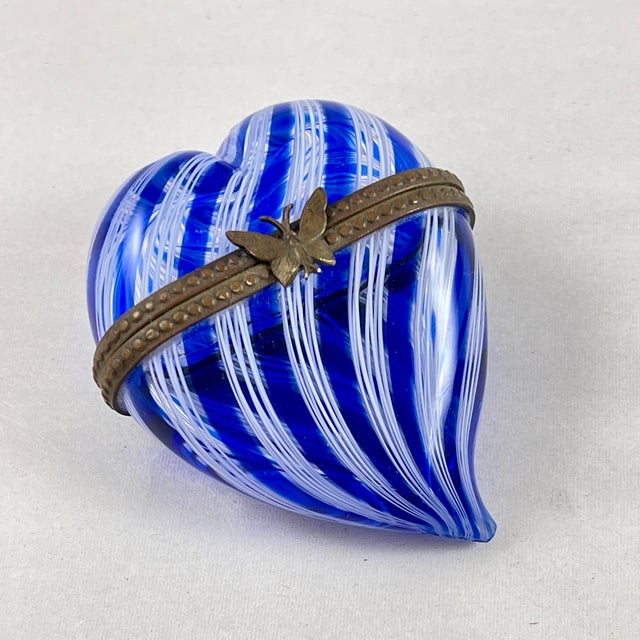 A metal braced heart shaped Venetian glass trinket box, Murano, Italy, circa 1970s. A swirled cobalt blue and white glass...