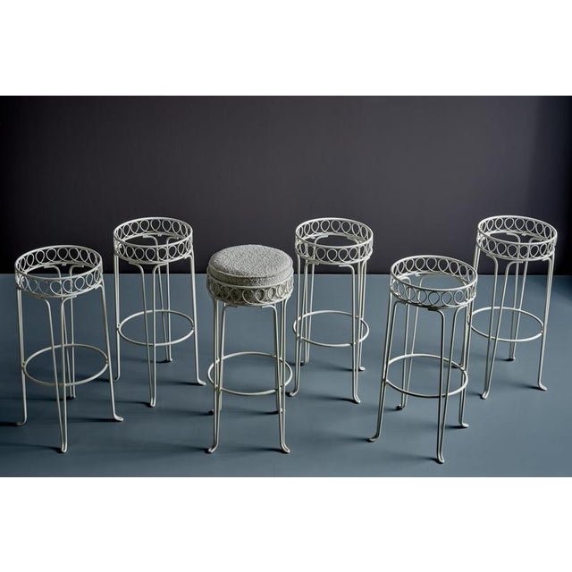 A set of six vintage bar stools featuring slender white-lacquered tubular metal frames with gently curved legs and...