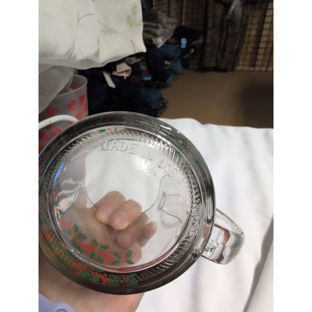Vintage glass mug featuring a festive holly design. • Clear glass construction with handle • Decorative holly and berry...