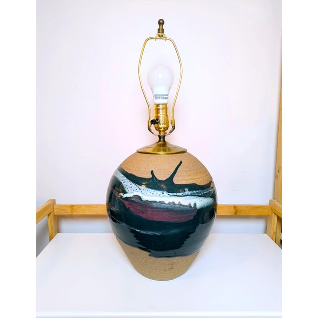 This is a vintage studio art pottery table lamp featuring a handcrafted textured clay base with a striking drip-glaze in...