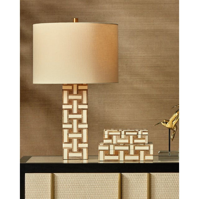 The Aarna Cream Table Lamp, with its basketweave pattern, is made of pieces of wood interspersed with strips of ivory...