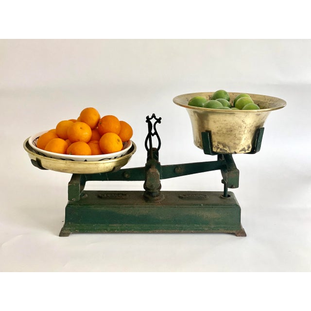 Antique Belgian cast iron balance scale with original brass pans. Age and use have left this scale with rust to its green...
