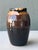 This vintage ceramic vase is an exemplary piece of studio pottery, featuring a rich, tri-color drip glaze that transitions...