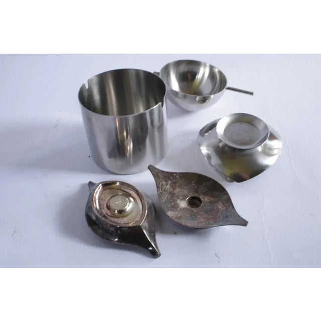 Stelton ashtray and small trays + Cohr candleholders This piece is designed in the style of the selected designer and/or...