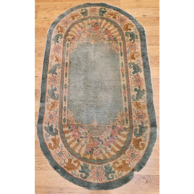 A truly rare and beautiful Art Deco Chinese area rug from the early 1900s in an unusual oval shape — a format always made...