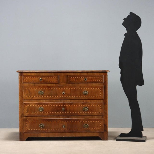 Walnut chest of drawers with maple trim and alternating woods. Front with five drawers, the first two of which, placed...