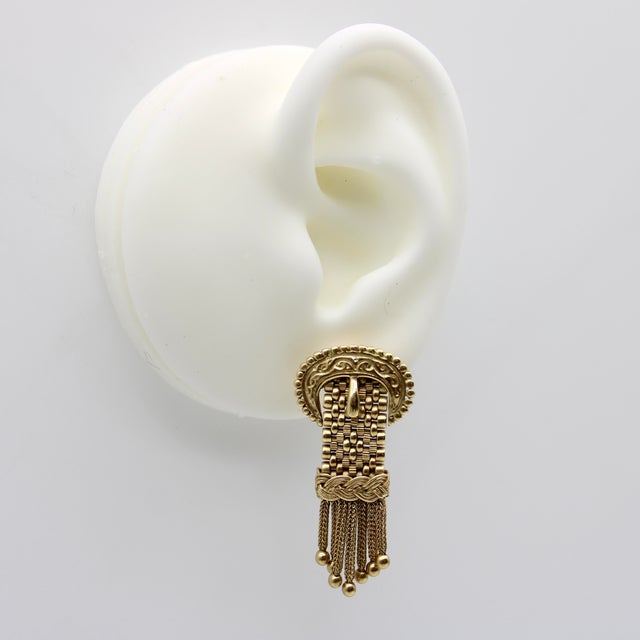 These stunning Victorian buckle earrings are crafted with bright yellow gold and feature delicate tassels that elegantly...