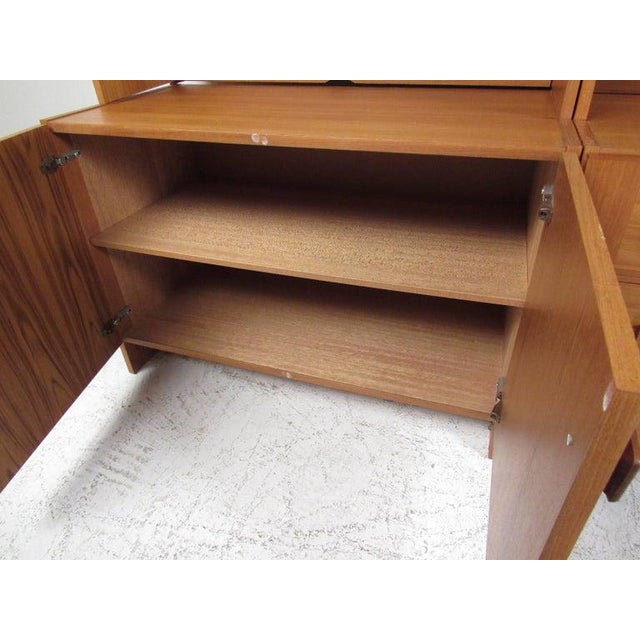 Impressive freestanding teak modular wall unit providing multiple storage and configuration options. The three base and...