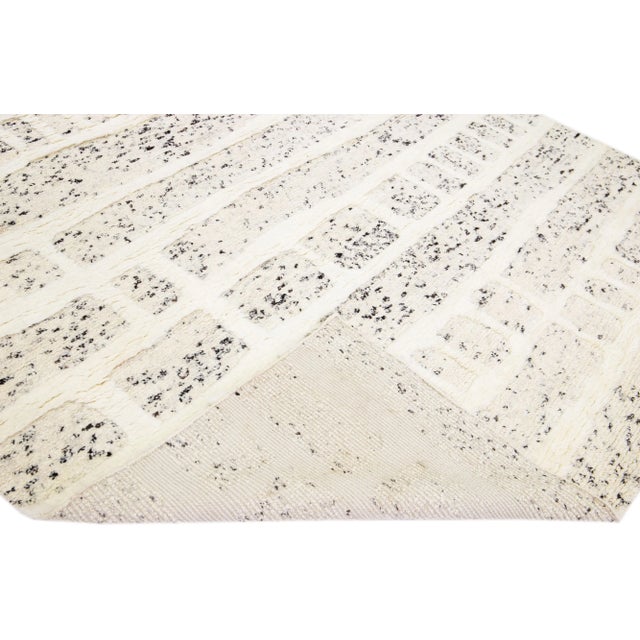 Beautiful modern Moroccan style hand-knotted wool rug with a beige and black color field and ivory accents in a gorgeous...