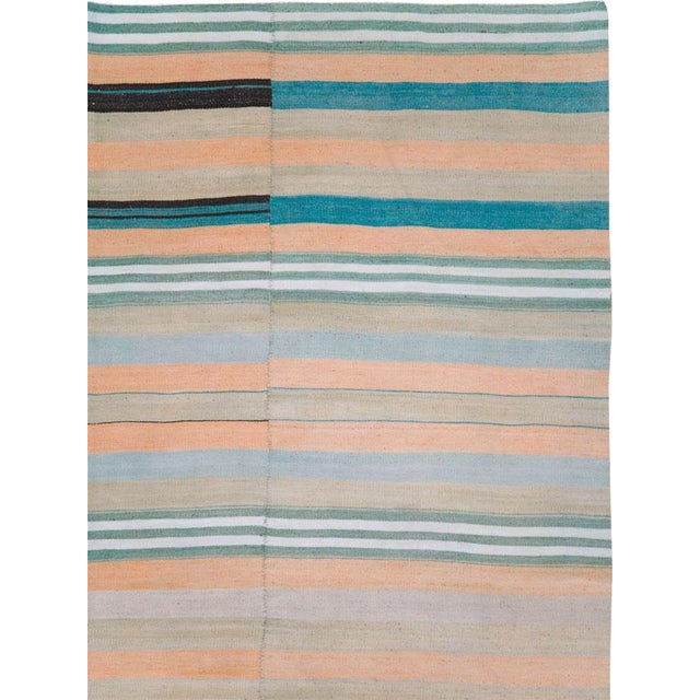 A vintage Turkish flatweave Kilim carpet in gallery format handmade during the mid-20th century with a striped pattern in...
