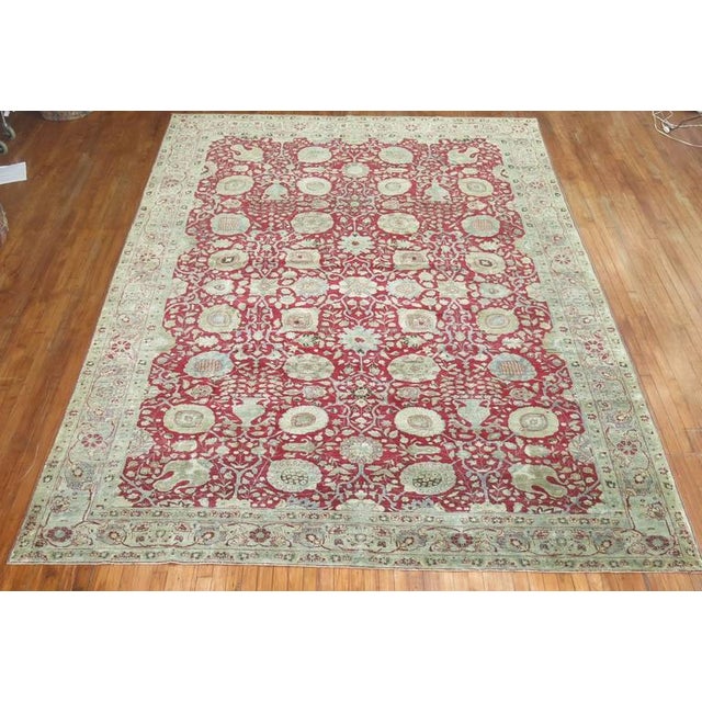 An early 20th century Antique Persian Tabriz rug in a predominant Chinese red color. Measures: 9'2'' x 13'2'' Like the...