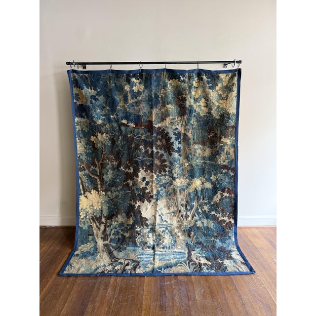 A French antique tapestry adorned with intricate motifs and decorative detailing that reveal the beautiful French...