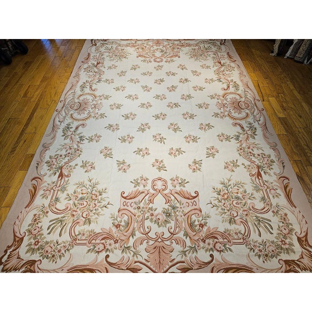This elegant vintage French Aubusson tapestry rug features a classic allover floral bouquet design rendered in a refined,...