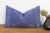 A four-petal flower-star medallion, hand block-printed in white, repeats across a deep indigo linen ground on this lumbar...