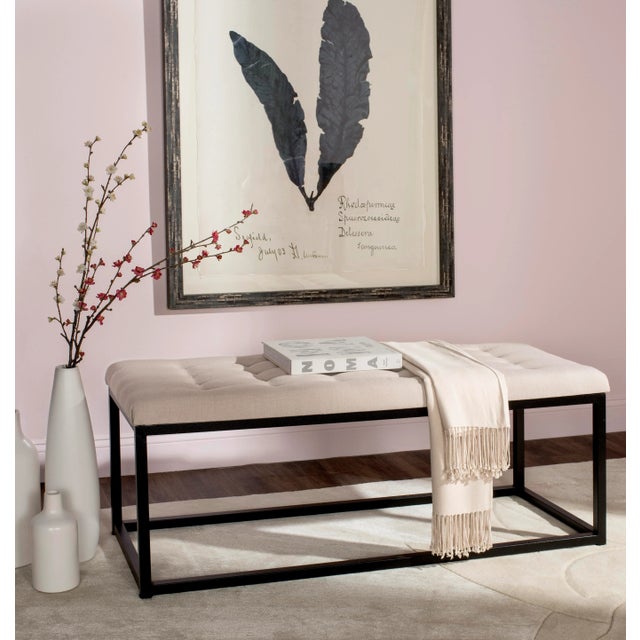 Graphic lines impart a designer look to the viewing bench, here with a beige tufted linen upholstered seat and black...