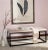Graphic lines impart a designer look to the viewing bench, here with a beige tufted linen upholstered seat and black...