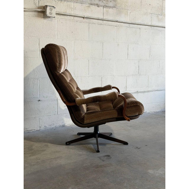 This plush lounge chair features an ergonomic high-back design with padded armrests and a smooth swivel base. Its inviting...