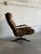 This plush lounge chair features an ergonomic high-back design with padded armrests and a smooth swivel base. Its inviting...