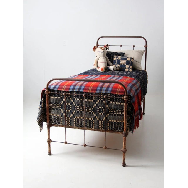 Antique late 19th century iron twin bed frame with clean, linear styling and classic knobbed accents forming a “stick and...