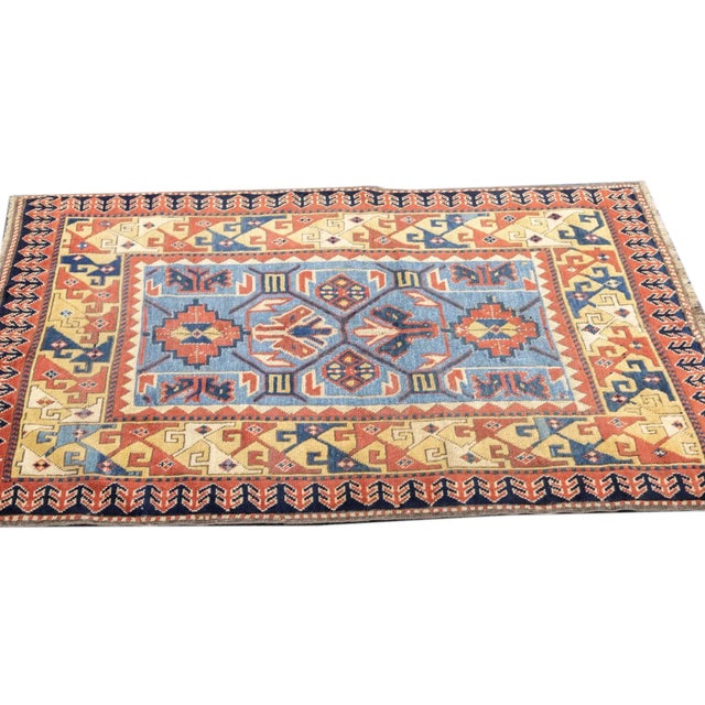 This SW Caucasian all wool scatter is in the general Kuba style, with a light blue field displaying a square and octagon...