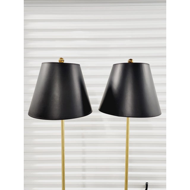 Sleek pair of vintage trumpet form brass floor lamps with sleek and stylish lines. The floor lamps seat on a black square...