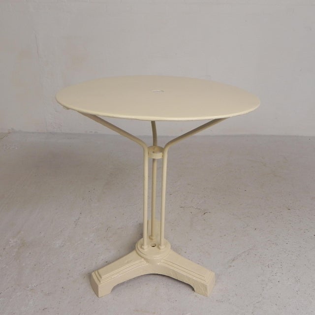 This bistro table served for years on the terrace of a French café. There is a round hole in the center of the tabletop...