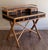 Attributed to E. Murio, this vintage Campaign-style faux bamboo writing desk showcases timeless Hollywood Regency and...