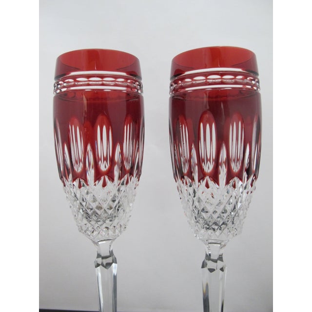 Pair of Waterford Crystal Clarendon champagne flutes in Ruby Red tone. Elegant stemware in vibrant ruby red tone cut-to-...