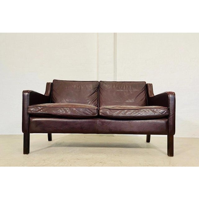 A superb vintage Danish two-seater sofa by Stouby, dating from the 1960s and upholstered in beautifully aged dark cognac...