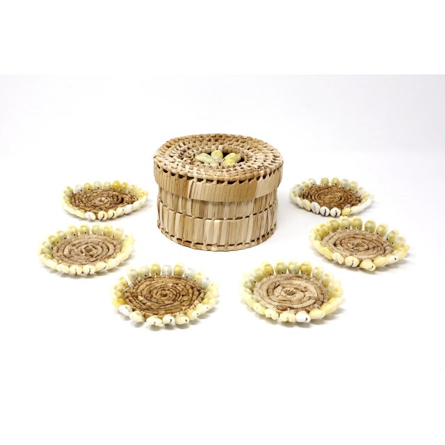 A vintage set of six beverage coasters and storage box, made of woven grass and puka shells. Excellent condition. box: 3...