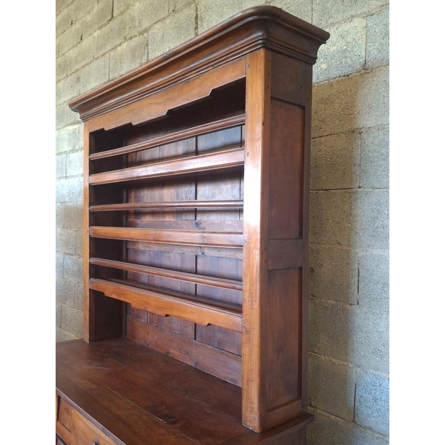 A superb, large, two-part sideboard in fruitwood, likely walnut or cherry, boasting a magnificent antique patina in warm...