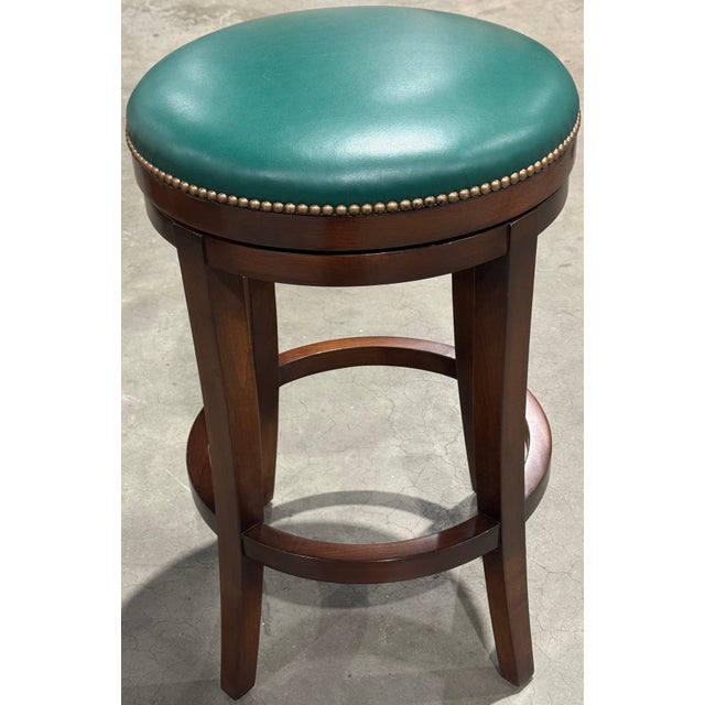 Two custom wood swivel bar stools in a walnut finish, designed for interior design firm, Katie Ridder Inc. Each seat...