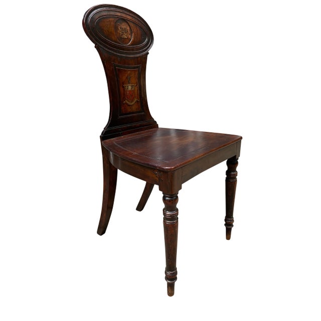 The chair back with oval crest with painted monogram over a tapered splat with coat of arms , wood seat raised on circular...
