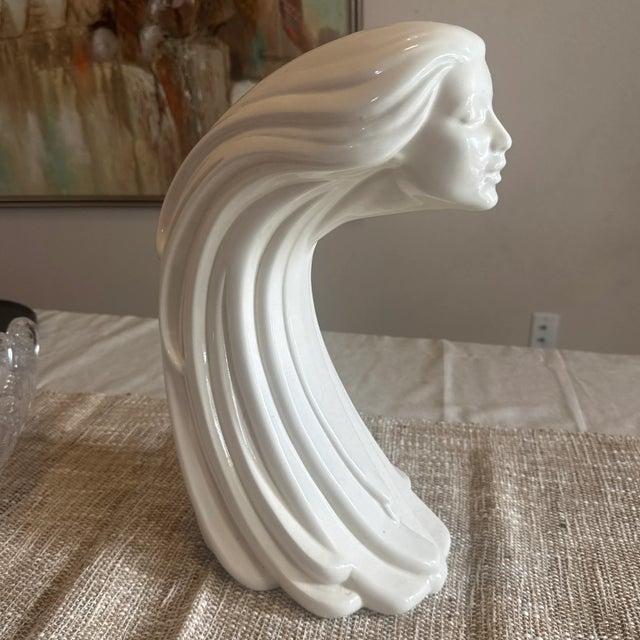 An eye-catching and evocative vintage ceramic sculpture depicting a stylized woman's face with long, flowing hair. This...