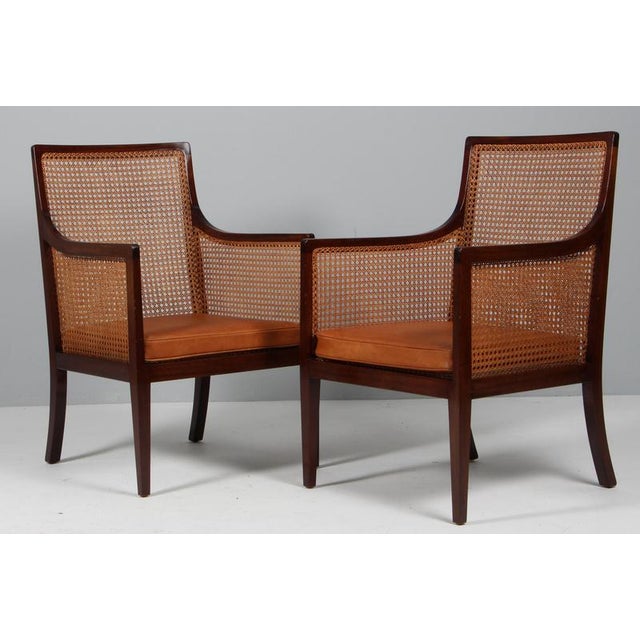 Ole Wanscher set of Bergeres lounge chairs in mahogany. Seat, back and sides with patinated cane. Cushions of patinated...
