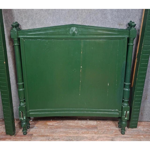 Directoire-style bed in green-painted wood. Composed of a headboard and footboard framed by turned uprights ending in...