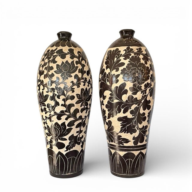 A striking pair of large ceramic vases in a high-contrast deep espresso - near black - and cream palette with carved...