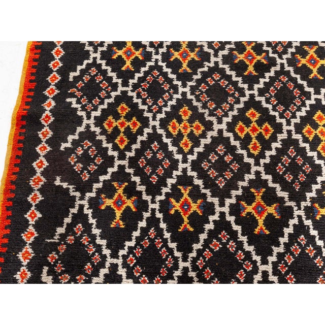 Vintage Moroccan Rug Size: 5'6" × 7'6" (167 × 228 cm) This vintage Moroccan rug features a striking geometric pattern set...
